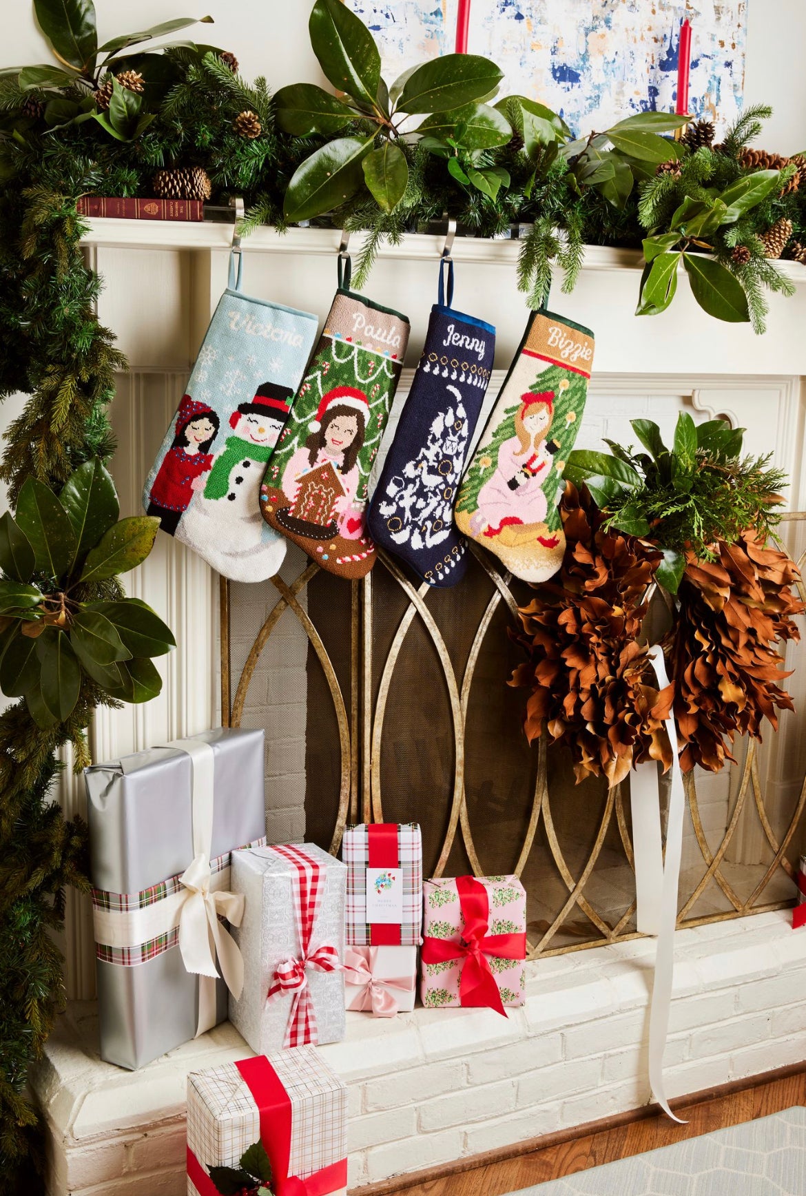 Festive mantle decorated with a Full Size Stockings, greenery, and holiday ornaments