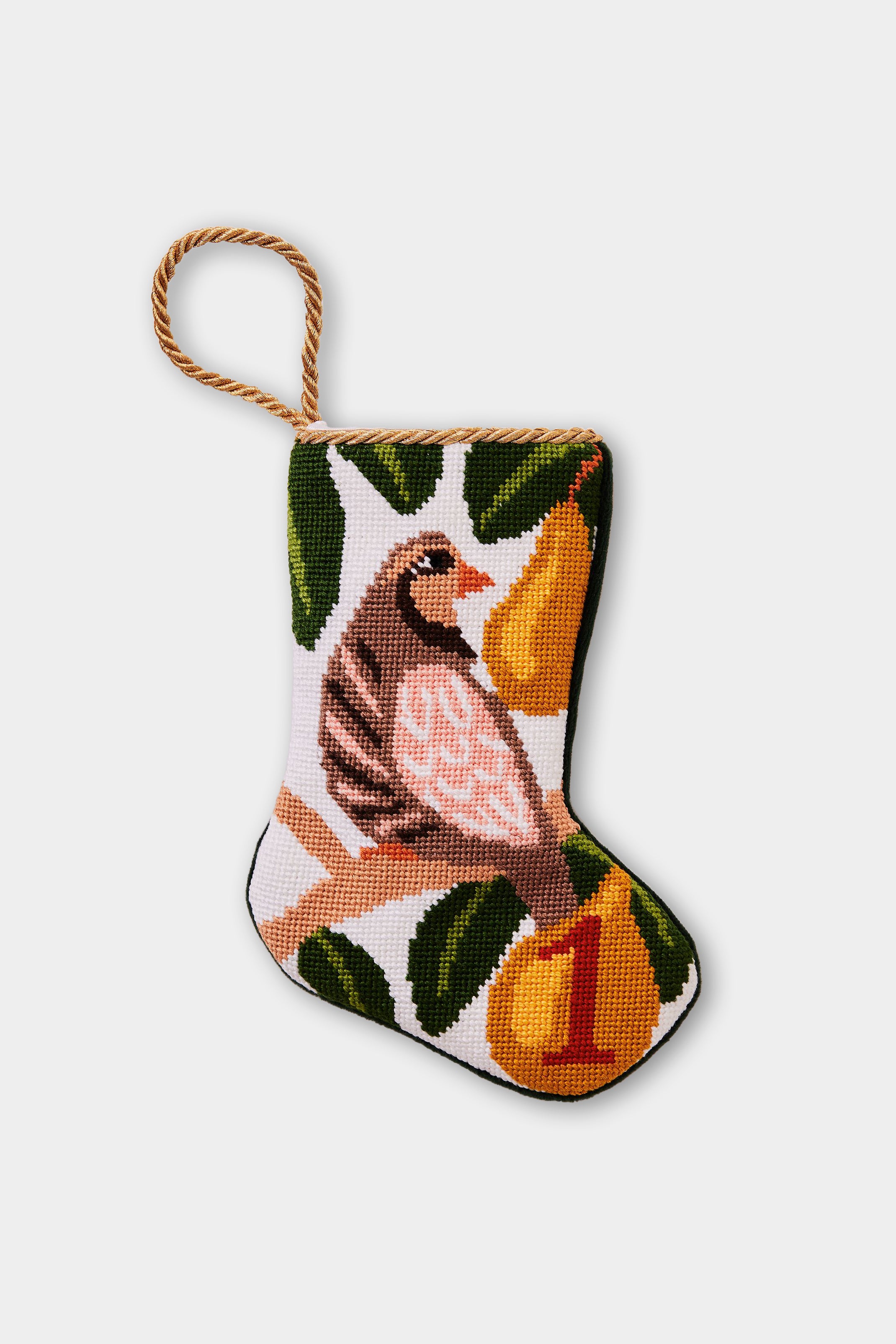 Needlepoint stocking featuring a partridge perched in a pear tree and green leaves on a white backdrop