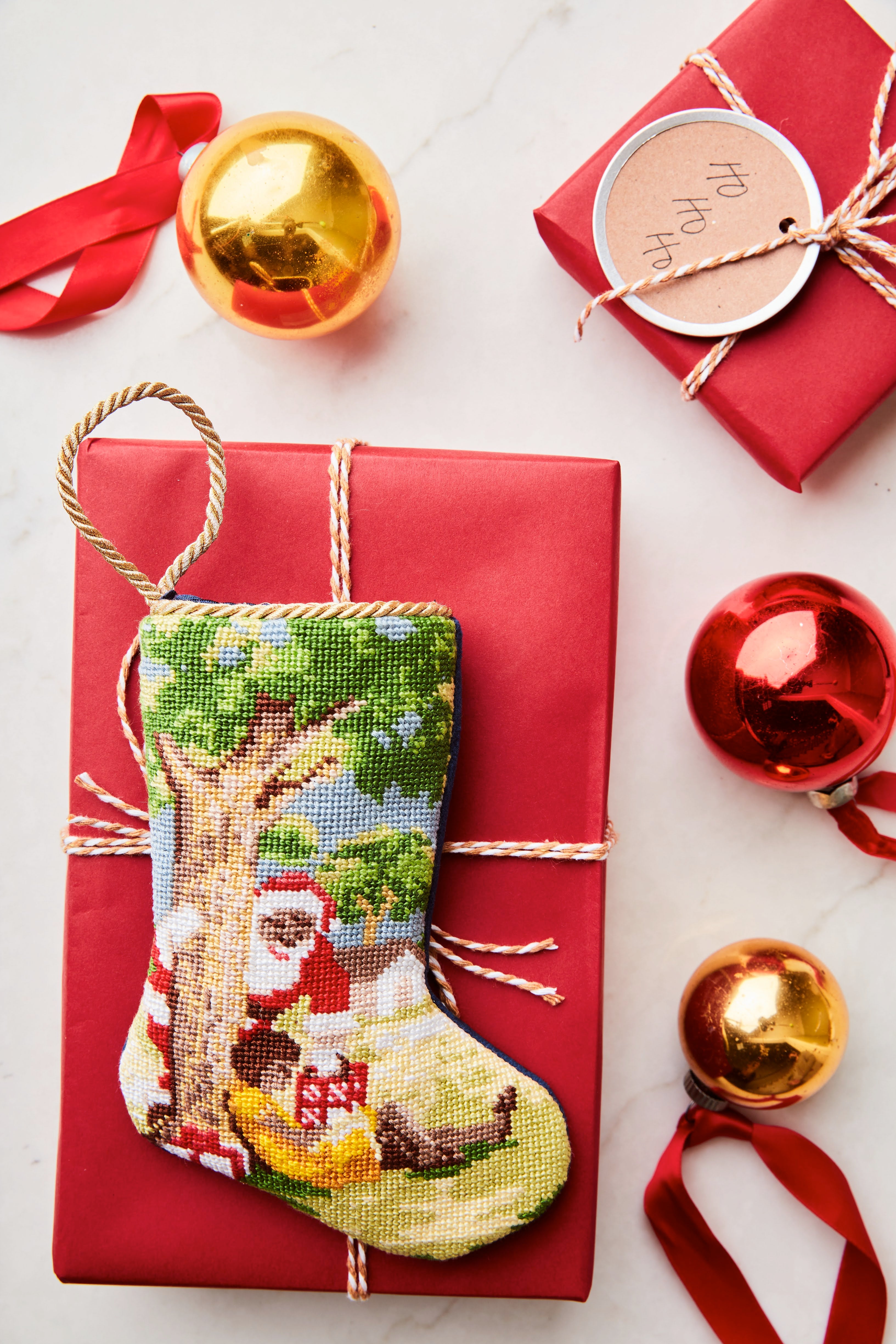 Bauble Stockings styled with gold ornaments, red gift wrap, and festive holiday decor