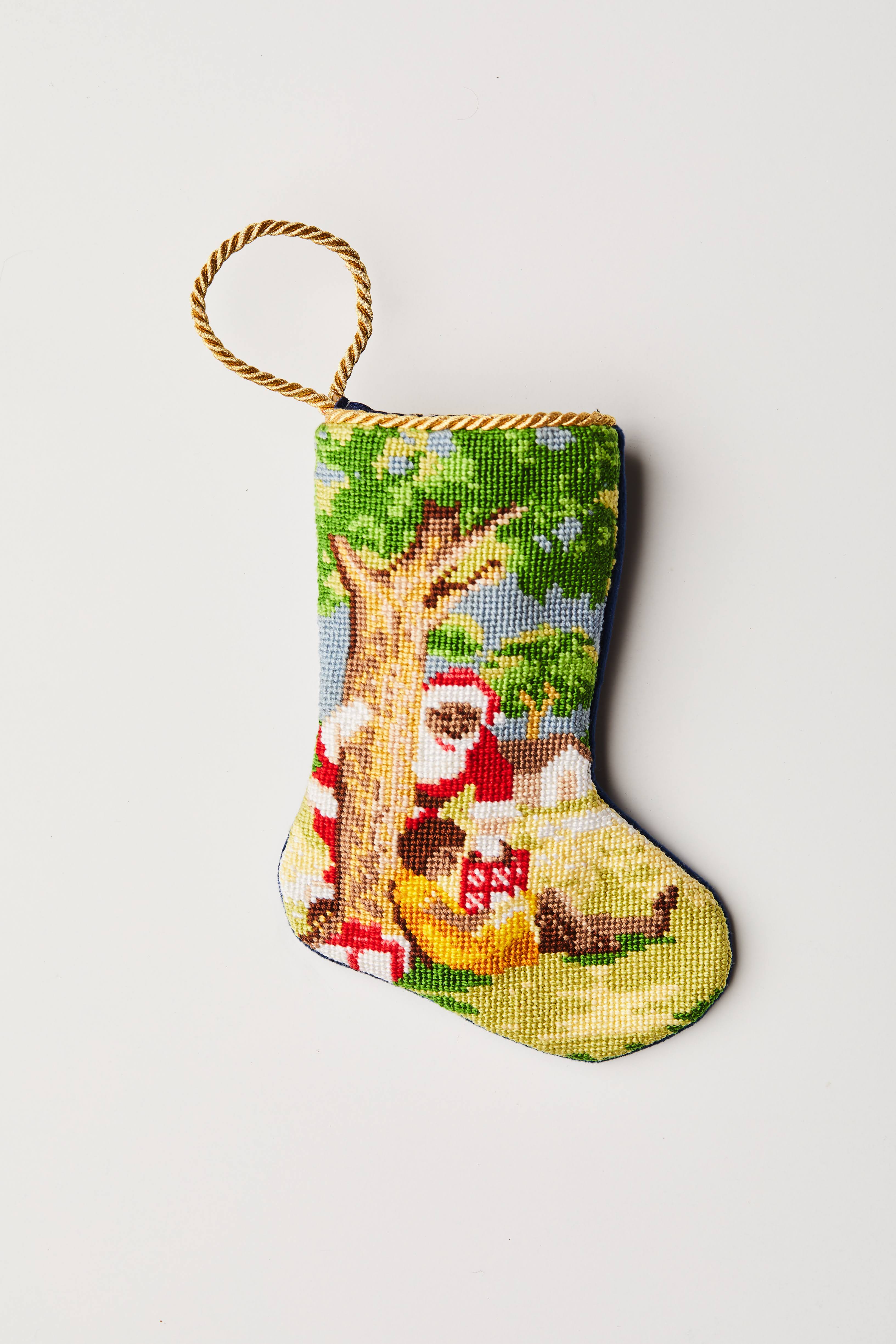 Hand-stitched Christmas stocking with Santa, tree, and gifts on a festive green background