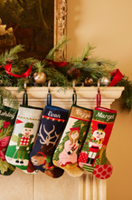 Colorful Christmas stockings with personalized names hanging on a fireplace mantle decorated with greenery and ribbons.