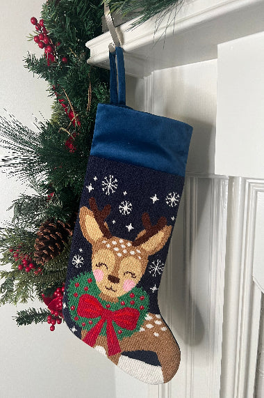 Full-size Christmas stocking featuring Dasher wearing a festive red bow and a green wreath around its neck on a navy blue backdrop with snowflakes