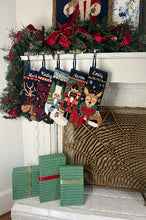 Festive mantle decorated with a Full Size Stockings, greenery, and holiday ornaments