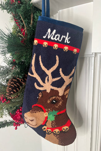 Full-size Christmas stocking with a monogrammed name in script featuring Donner the reindeer adorned with a red harness with jingle bells, set against a navy blue background