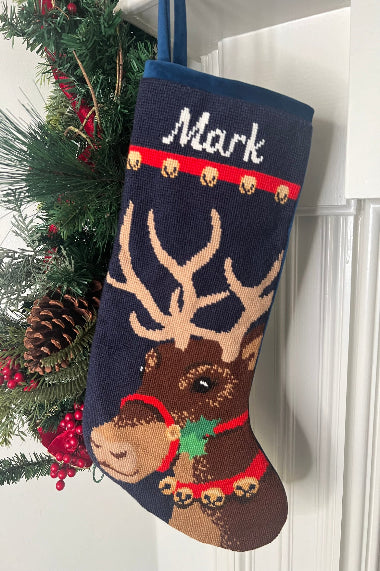 Full-size Christmas stocking with a monogrammed name in script featuring Donner the reindeer adorned with a red harness with jingle bells, set against a navy blue background