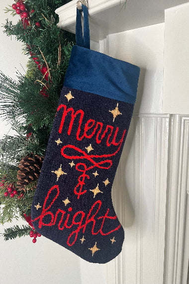 Full-size Christmas stocking featuring the Merry & Bright in bold red lettering, adorned with twinkling golden stars on a navy blue background