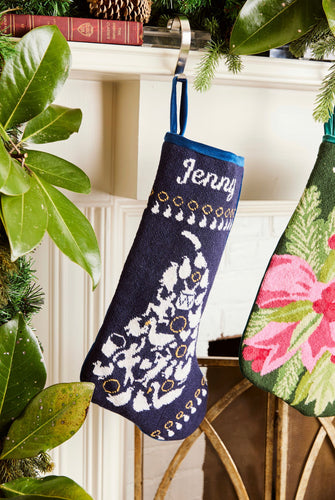 Full-size Christmas stocking with a monogrammed name in script, showcasing intricate festive designs against a dark blue background