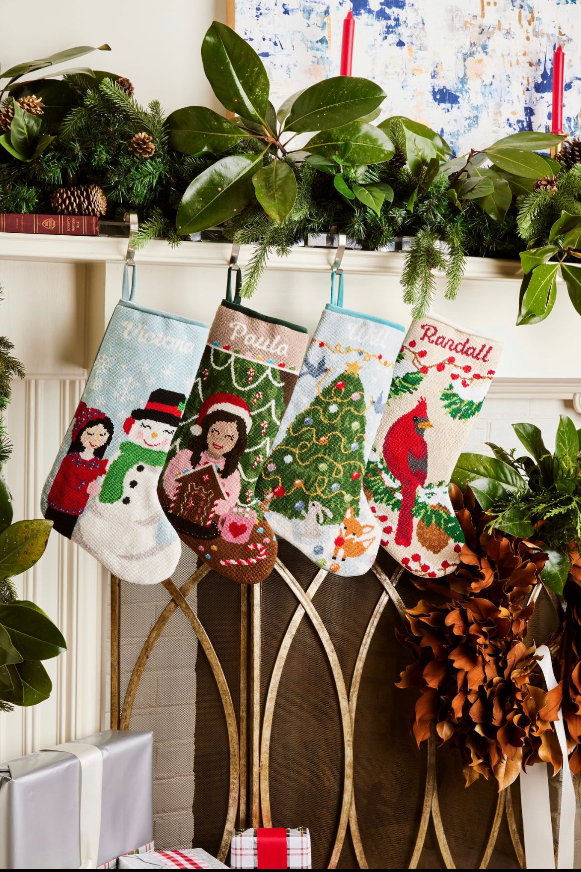 Festive mantle decorated with a Full Size Stockings, greenery, and holiday ornaments