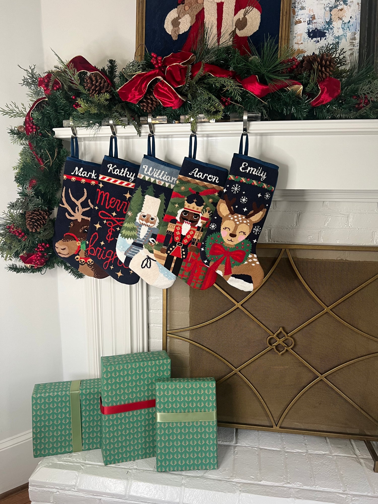 Festive mantle decorated with a Full Size Stockings, greenery, and holiday ornaments
