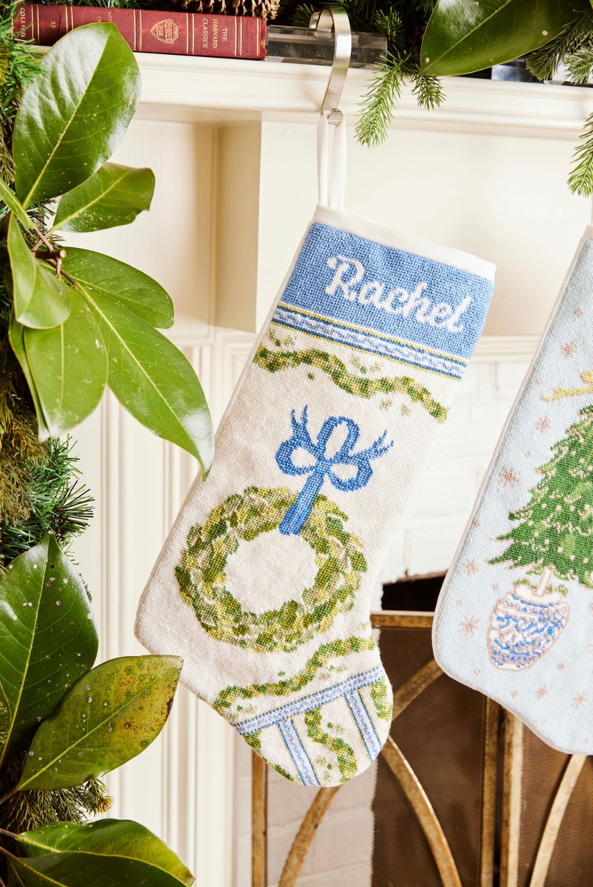 Full-size Christmas stocking with a monogrammed name in script featuring a festive wreath and ornaments design on white backdrop