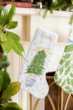 Full-size Christmas stocking with a monogrammed name in script featuring a vibrant, hand-stitched Christmas tree adorned with glittering ornaments on a soft light blue background