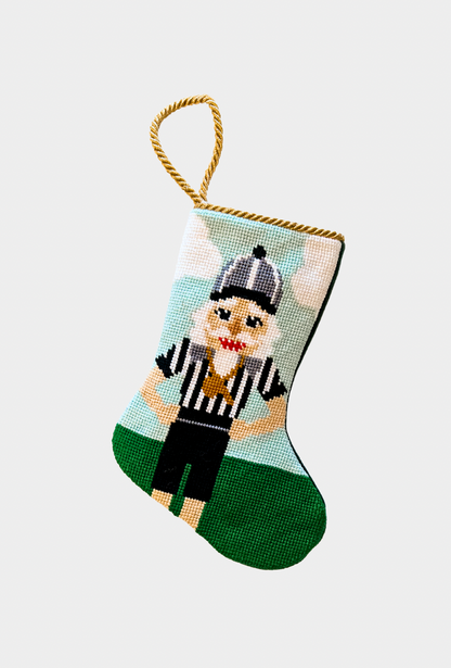 Hand-stitched stocking with sports-themed referee nutcracker in striped uniform with whistle on festive green field