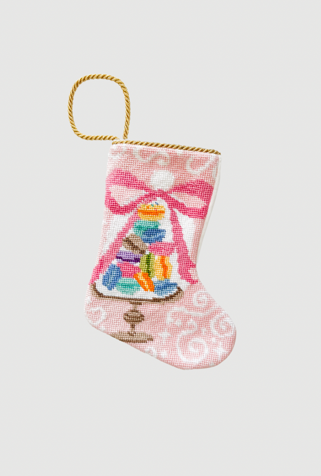 Needlepoint Bauble Stockings featuring colorful stacked macarons on festive pink background
