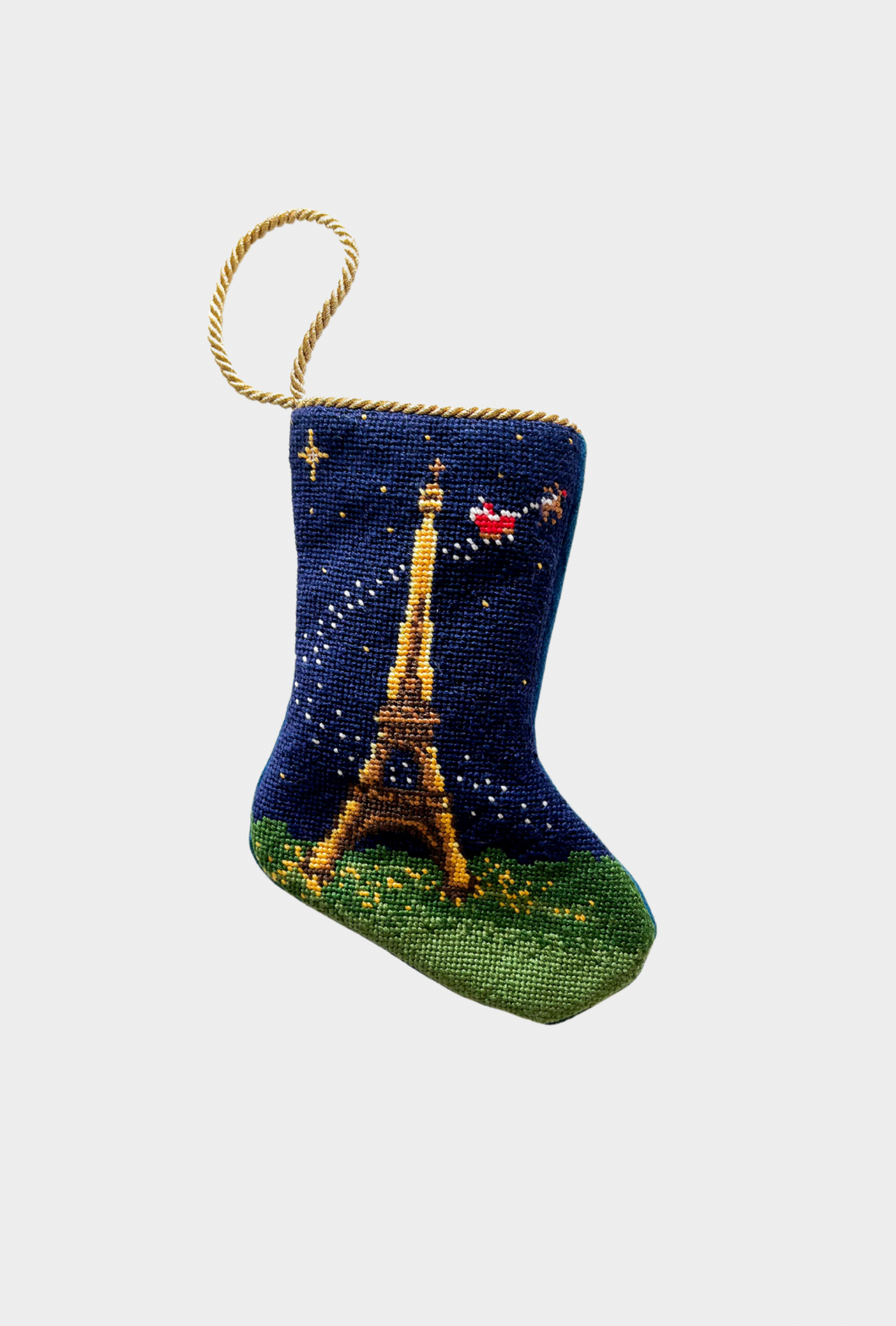Hand-stitched needlepoint stocking featuring the Eiffel Tower with Santa flying over the Paris night sky on a navy background.