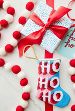 HO HO HO Bauble Stockings styled on vibrant red background with festive holiday accents