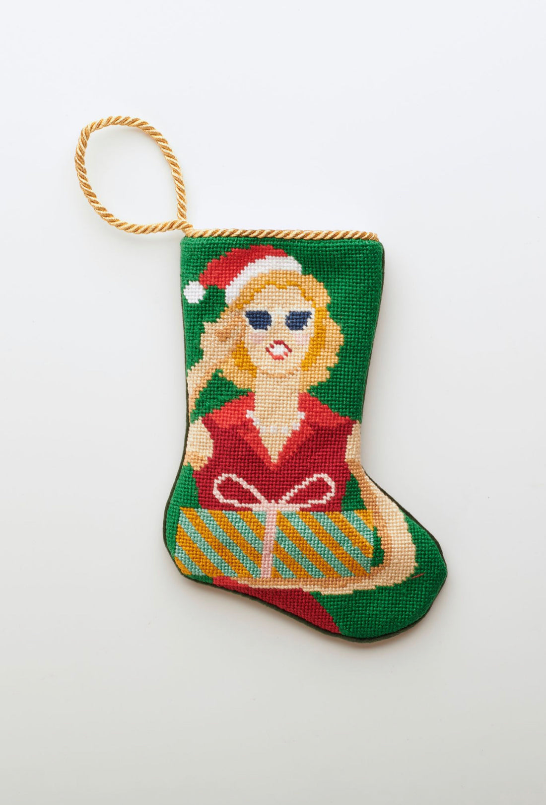 Needlepoint Bauble Stockings with festive Mrs. Claus design in red holiday outfit on green background