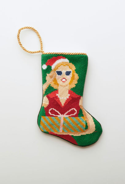Needlepoint Bauble Stockings with festive Mrs. Claus design in red holiday outfit on green background