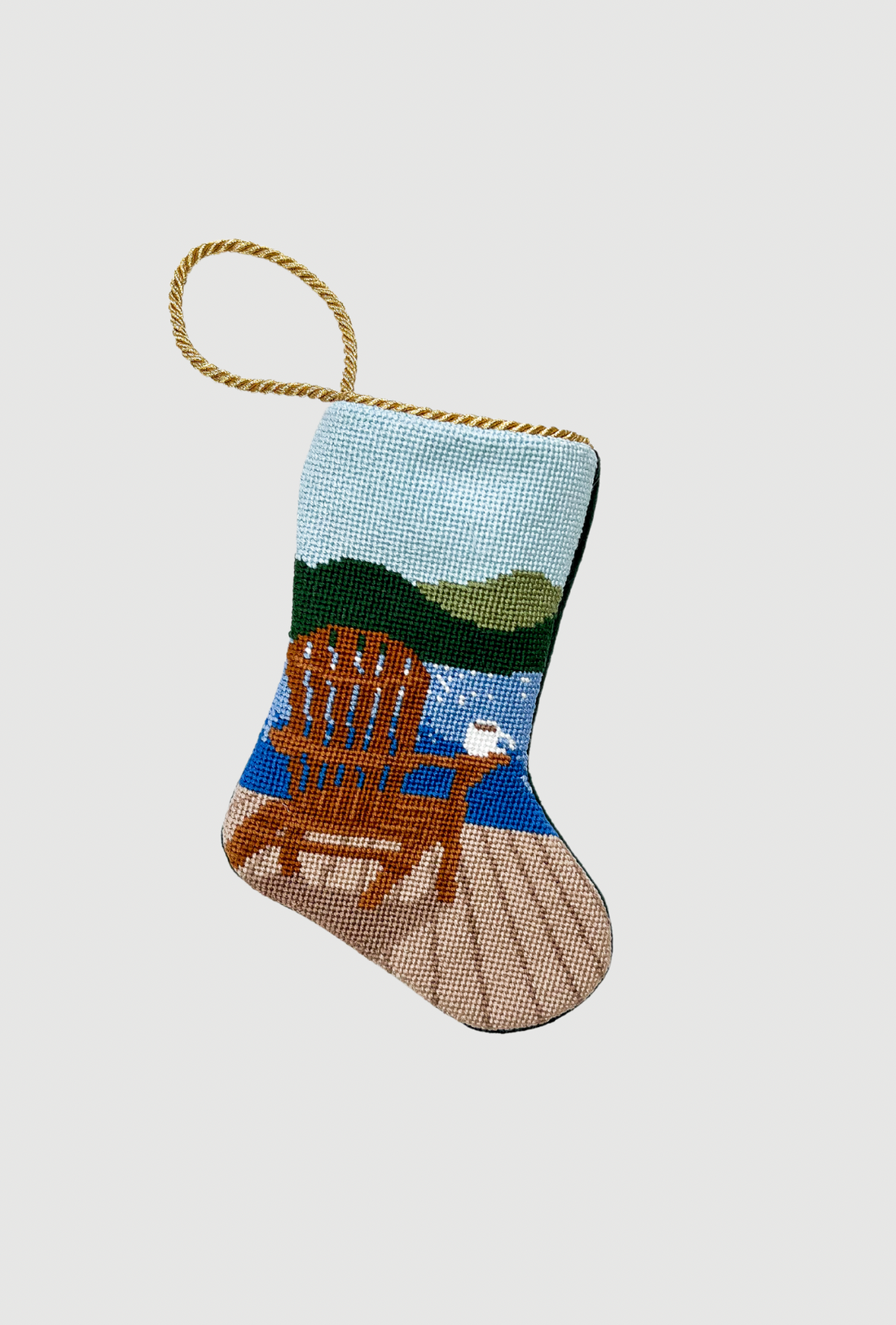 Needlepoint Bauble Stockings showcasing lakeside scene with wooden chair and serene green hills