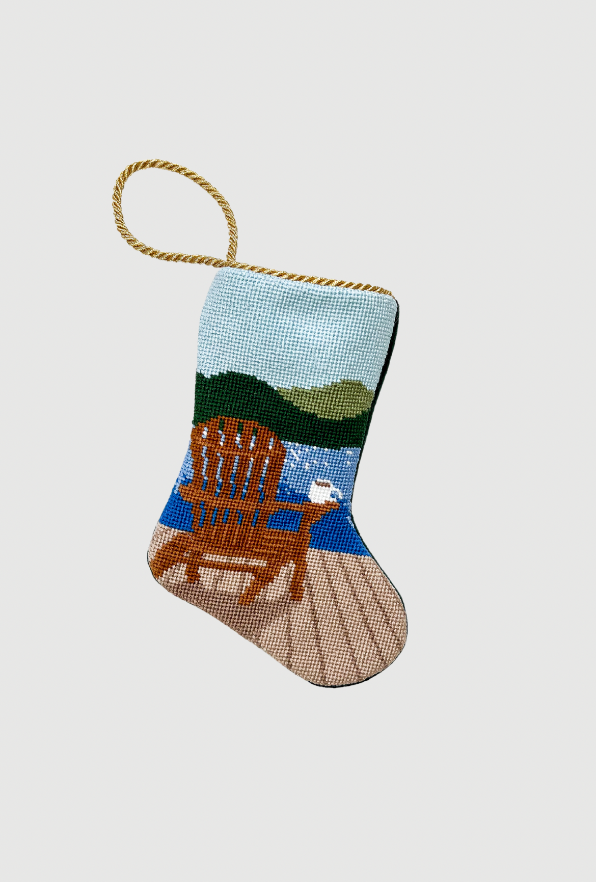 Needlepoint Bauble Stockings showcasing lakeside scene with wooden chair and serene green hills