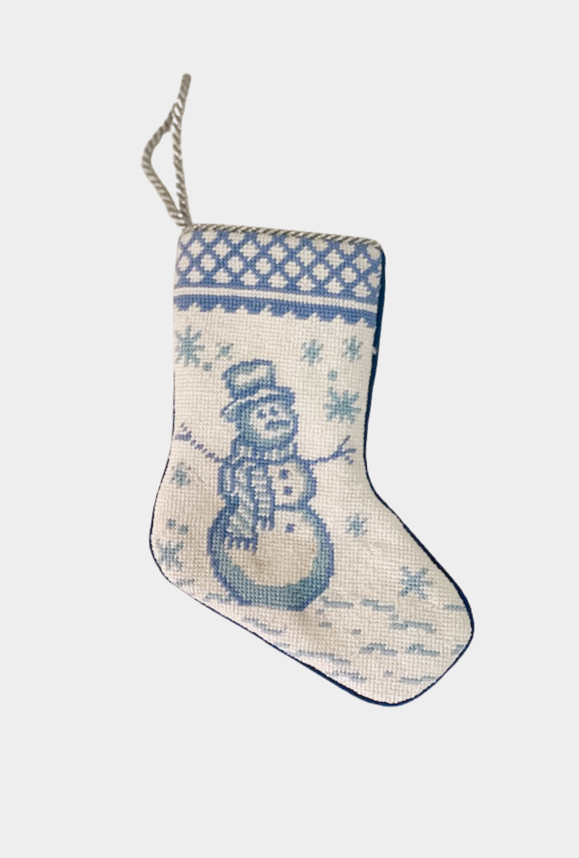Needlepoint stocking featuring a blue snowman surrounded by falling snowflakes with decorative border