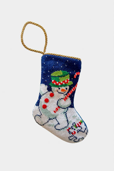 Hand-stitched Christmas stocking featuring jolly snowman in green hat with candy cane on snowy navy background