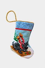 Hand-stitched Christmas stocking featuring Scottie the dog in red scarf riding a sled through a snowy landscape