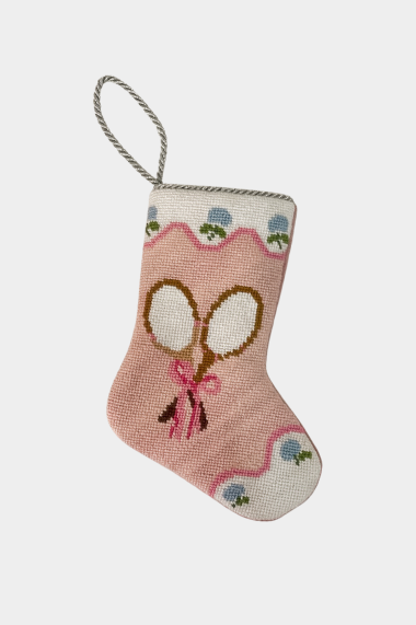 Needlepoint stocking featuring crossed tennis rackets with bow on pink background with scalloped floral trim