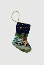Hand-stitched Christmas stocking featuring Charleston’s Rainbow Row under a starry sky with Santa’s sleigh overhead