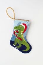 Needlepoint stocking featuring a dinosaur holding a candy cane and wearing a Santa hat