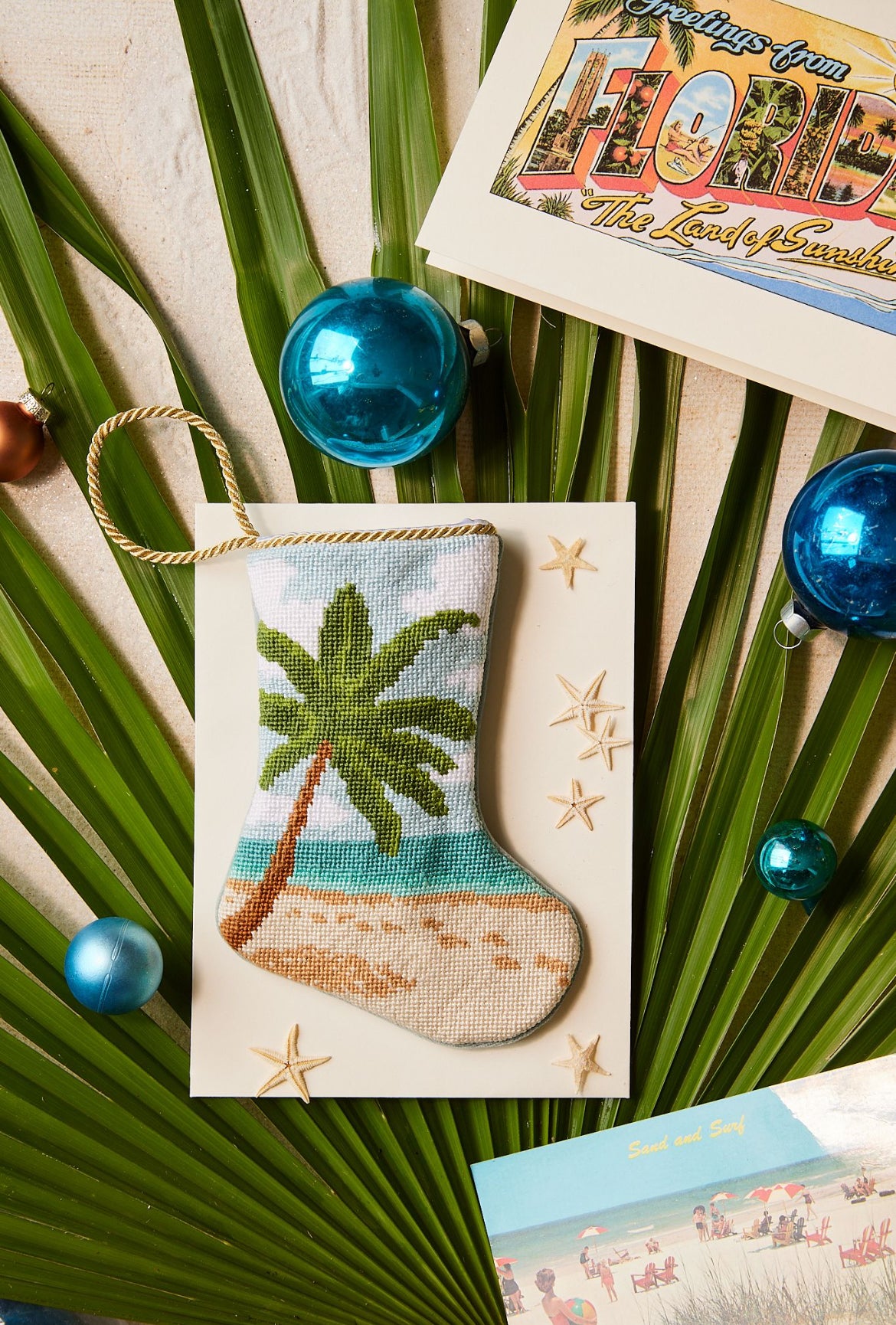 Bauble Stockings styled among tropical palm leaves and holiday ornaments for coastal decor