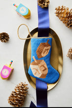 Hanukkah-themed needlepoint stocking displayed with festive holiday decor