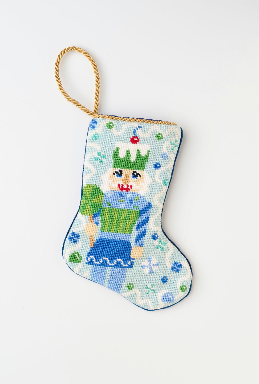 Hand-stitched needlepoint stocking featuring a candy-themed nutcracker in sweet festive accents