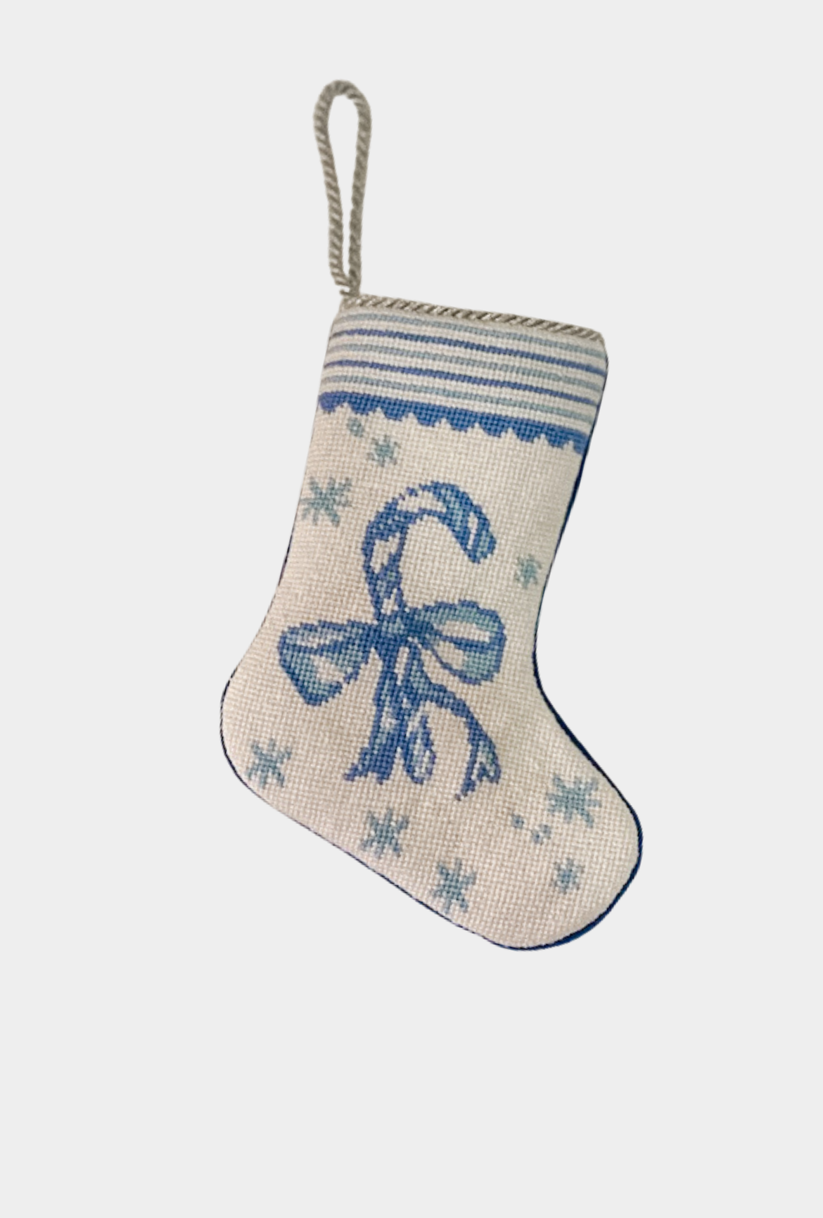 Needlepoint stocking featuring a blue candy cane tied with a bow, surrounded by snowflakes with decorative border