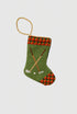 Needlepoint stocking with golf clubs, golf ball, and red plaid cuff on green background