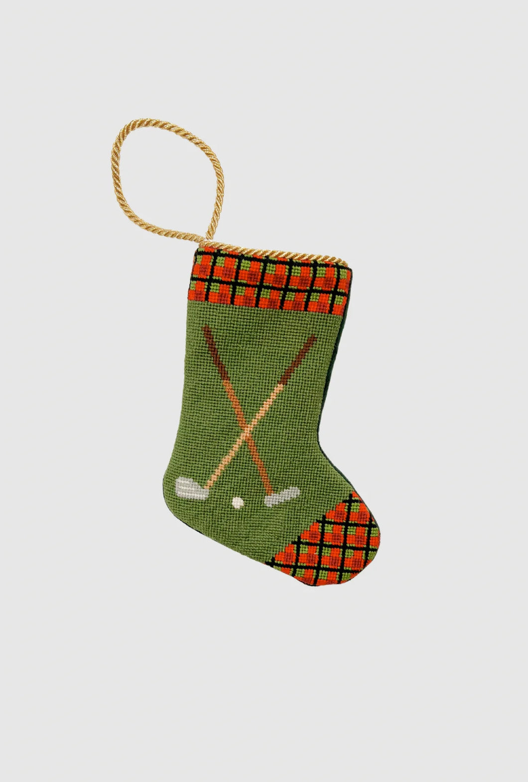 Needlepoint stocking with golf clubs, golf ball, and red plaid cuff on green background
