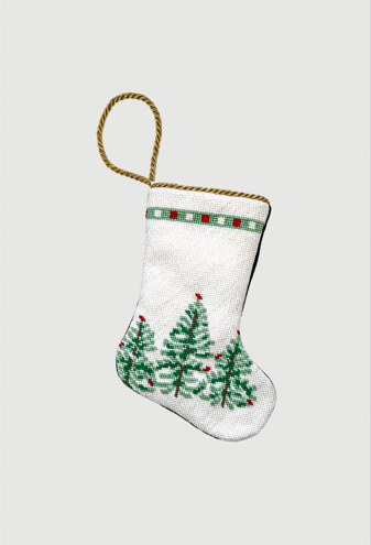 Hand-stitched needlepoint stocking featuring green Christmas trees and red ornaments on a snowy white background