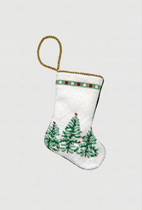 Hand-stitched needlepoint stocking featuring green Christmas trees and red ornaments on a snowy white background