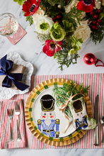 Holiday-themed table styled with Bauble Stockings, nutcracker plate, festive greenery, and red decor accents
