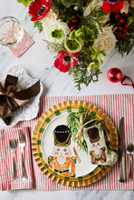 Holiday-themed table styled with Bauble Stockings, nutcracker plate, festive greenery, and red decor accents