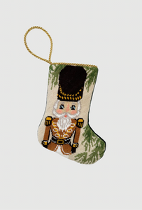 Needlepoint Bauble Stockings featuring a nutcracker in gold uniform with metallic accents and festive green trim