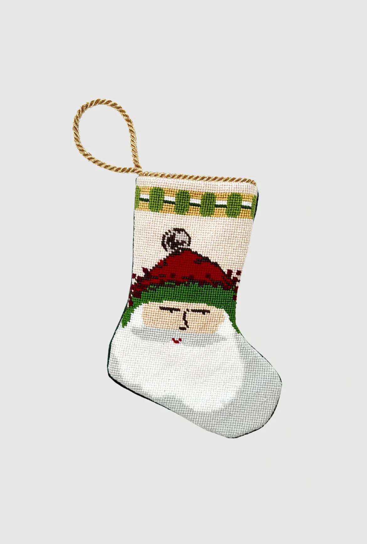 Handmade Christmas stocking with Old St. Nick in green-trimmed hat on festive holiday scenery