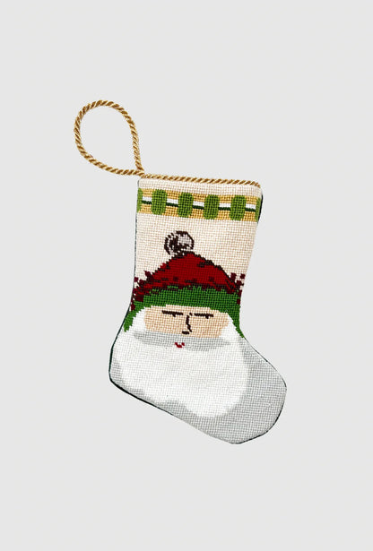 Handmade Christmas stocking with Old St. Nick in green-trimmed hat on festive holiday scenery