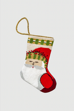 Hand-stitched Christmas stocking featuring Old St. Nick with striped hat and twig staff against festive backdrop
