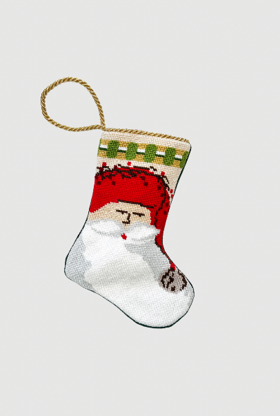 Christmas needlepoint stocking with Old St. Nick in red hat and twig staff on festive holiday background