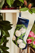 Full-size Christmas stocking with a monogrammed name in block featuring a silver bells and green garland on navy blue background