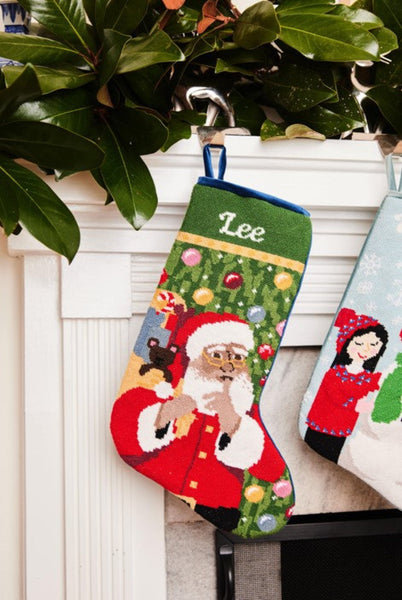 Full-size Christmas stocking with a monogrammed name in script featuring Santa holding gifts in red suit and green ornamented background