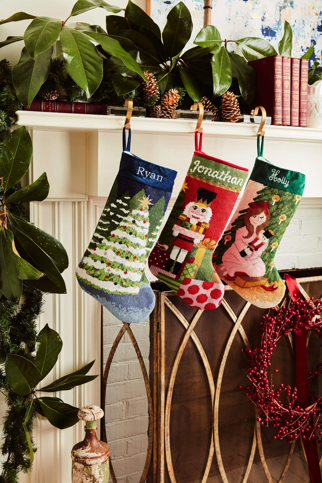 Festive mantle decorated with a Full Size Stockings, greenery, and holiday ornaments