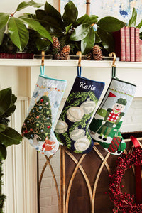 Festive mantle decorated with a Full Size Stockings, greenery, and holiday ornaments
