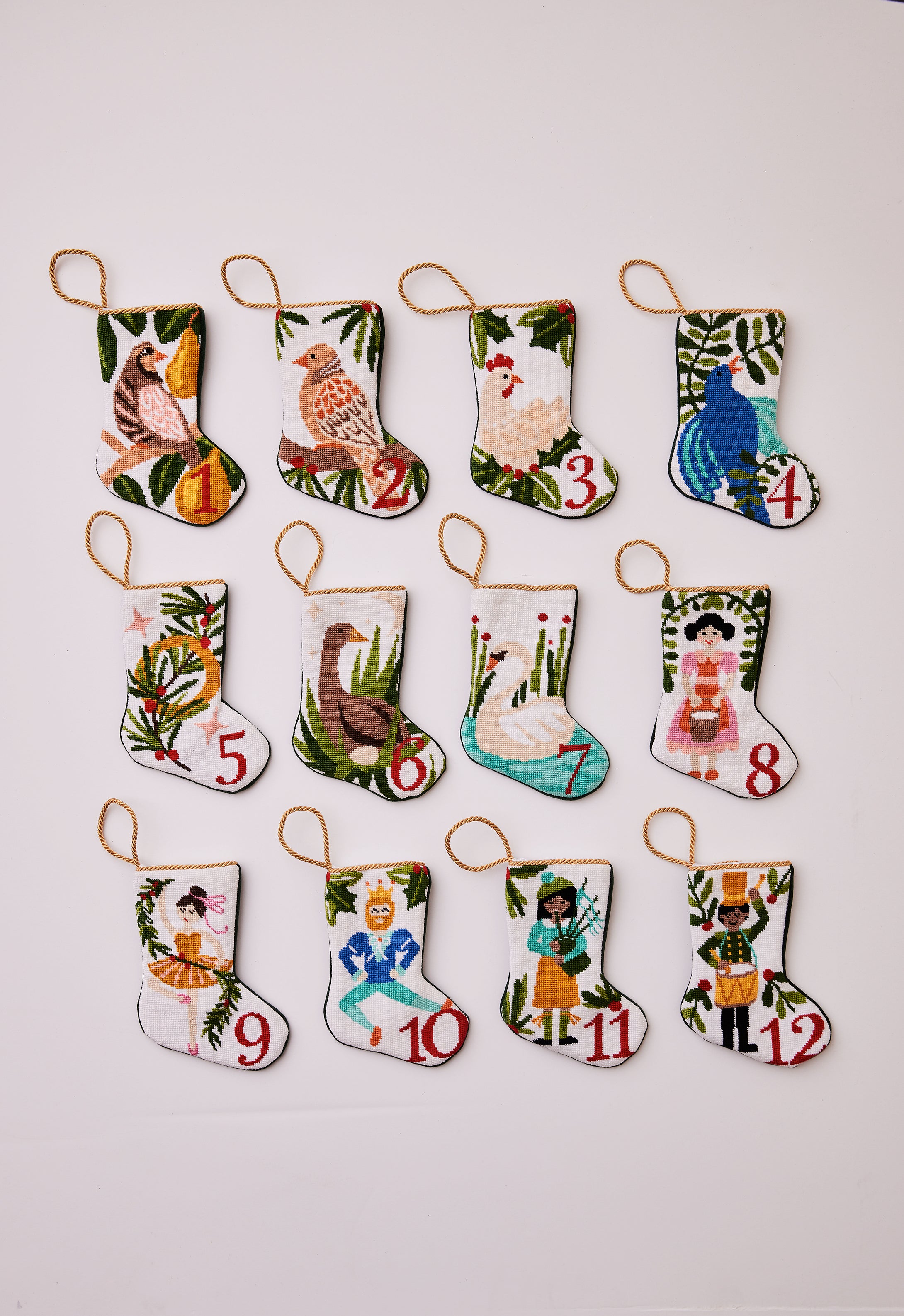 Full set of 12 hand-stitched needlepoint stockings featuring a unique design for each of the "12 Days of Christmas." Each stocking showcases vibrant colors with intricate designs