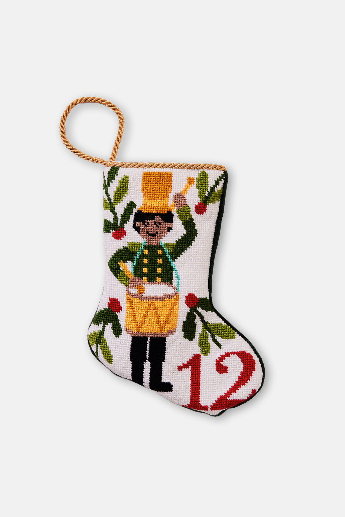 Hand-stitched Christmas stocking featuring drummer in green coat with yellow hat surrounded by greenery on white background